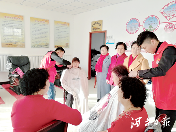 沙州镇志愿者为居民义务理发。